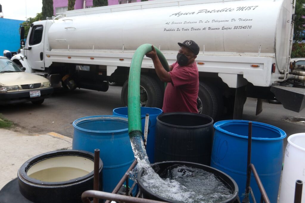 Un trabajador de una pipa de agua suministró botes de habitantes de la Unidad Habitacional Minas Polvorilla Acapatzingo, alcaldía Iztapalapa