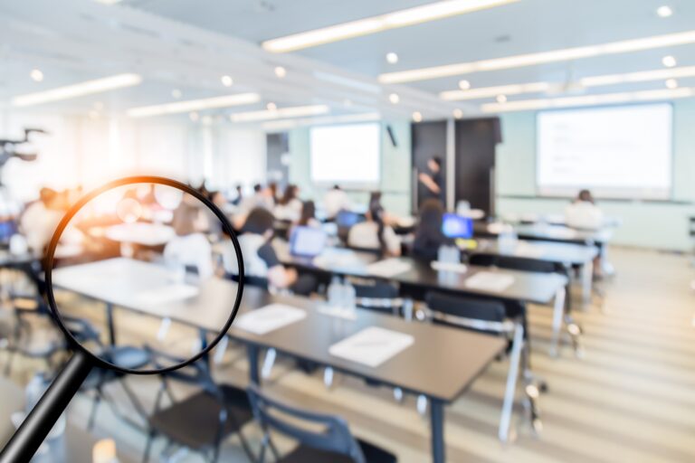 Aula moderna con estudiantes y pantallas difusas, representando la educación excluida en Perú y las barreras que enfrentan jóvenes y adultos mayores.
