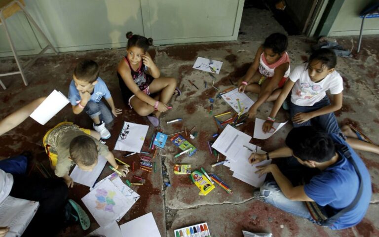 Niños en aula sin electricidad ni biblioteca como símbolo de la urgencia de justicia educativa universal