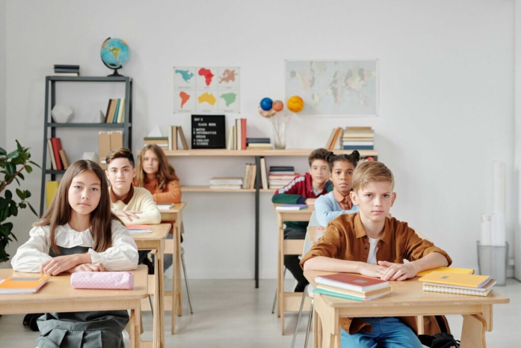 Niños y jóvenes en aula moderna con acceso equitativo a educación global e innovación tecnológica