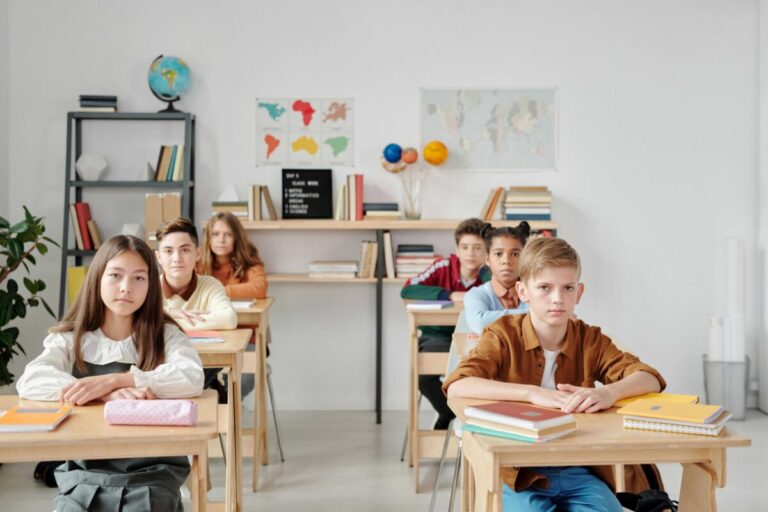 Niños y jóvenes en aula moderna con acceso equitativo a educación global e innovación tecnológica