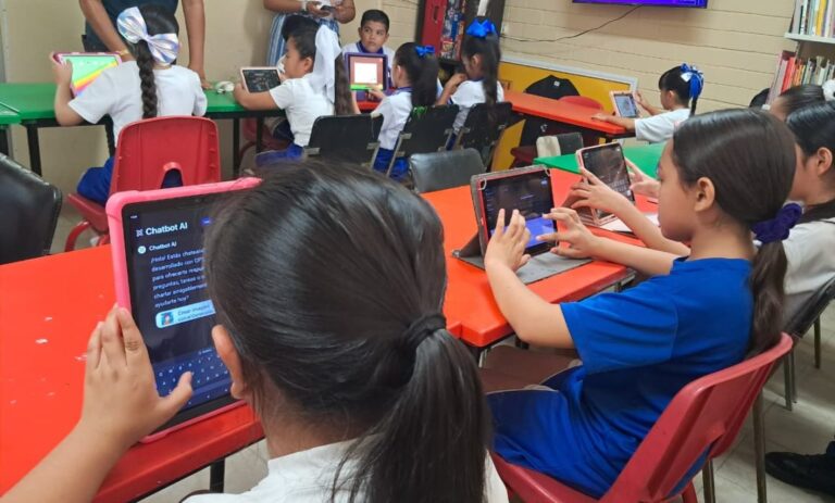 Estudiantes diversos interactuando con tecnología educativa en escuela de México, representando acceso y equidad
