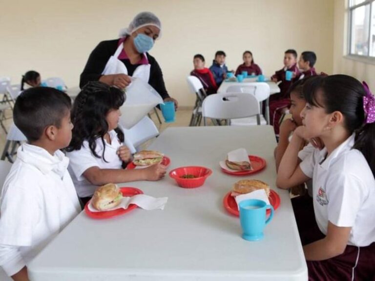 Niños en escuela de tiempo completo recibiendo alimentación gratuita en aulas llenas de actividad educativa