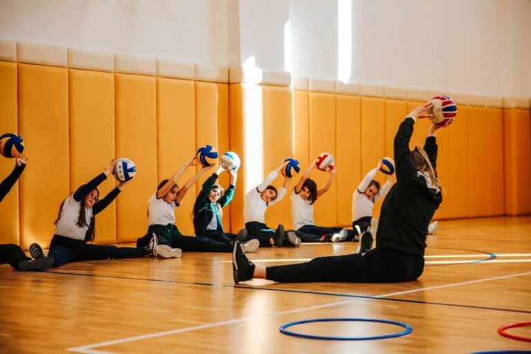 Profesora de educación física en España durante clase escolar, con estudiantes activos y ambiente de confianza educativa