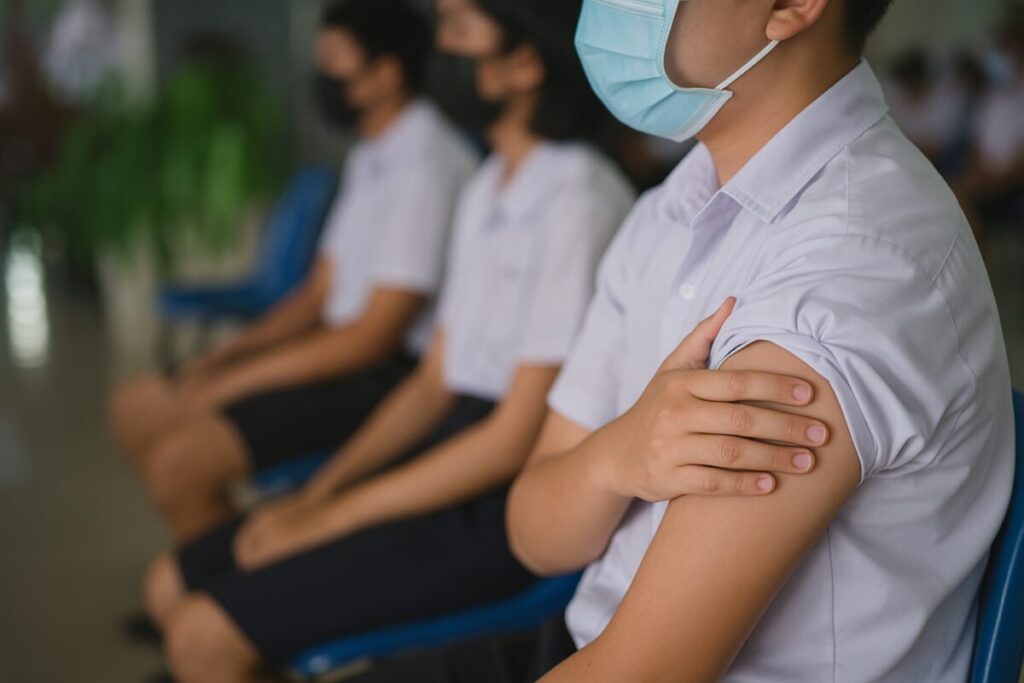 Estudiantes con uniforme y cubrebocas en escuela mexicana tras recibir vacuna por enfermedades en escuelas