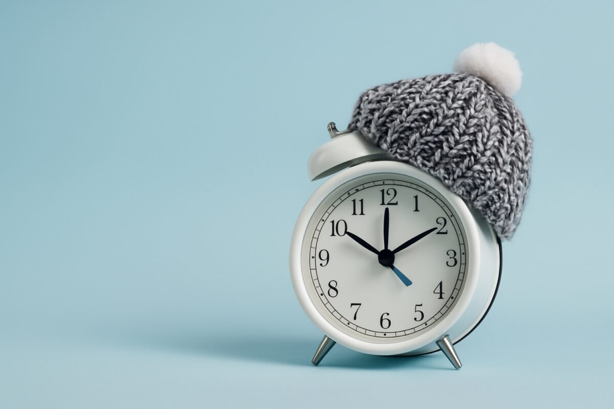 Reloj despertador con gorro de invierno representa el cambio al horario de invierno en escuelas mexicanas