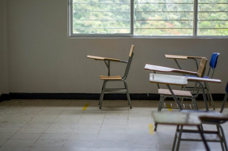Grupo de estudiantes en un aula vacía, reflejando la crisis educativa en México por falta de evaluación y políticas claras