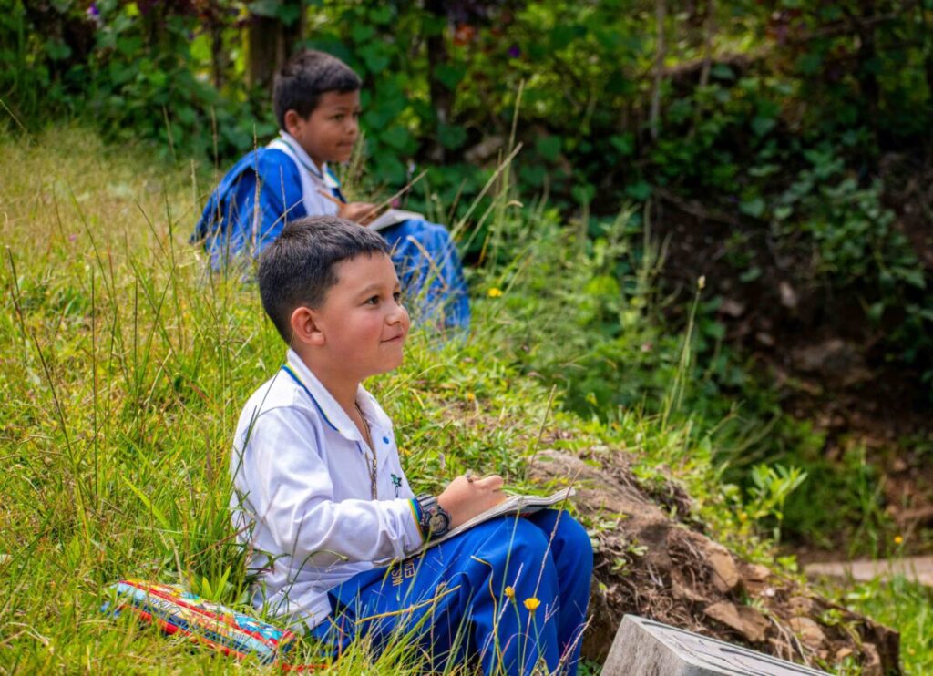 Fotografía de docentes y estudiantes trabajando en un aula comunitaria que promueve educación crítica en México