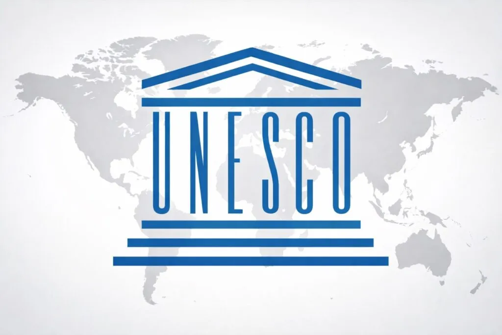 Logotipo de la UNESCO con mapa mundial de fondo, representa el compromiso global con la alfabetización digital