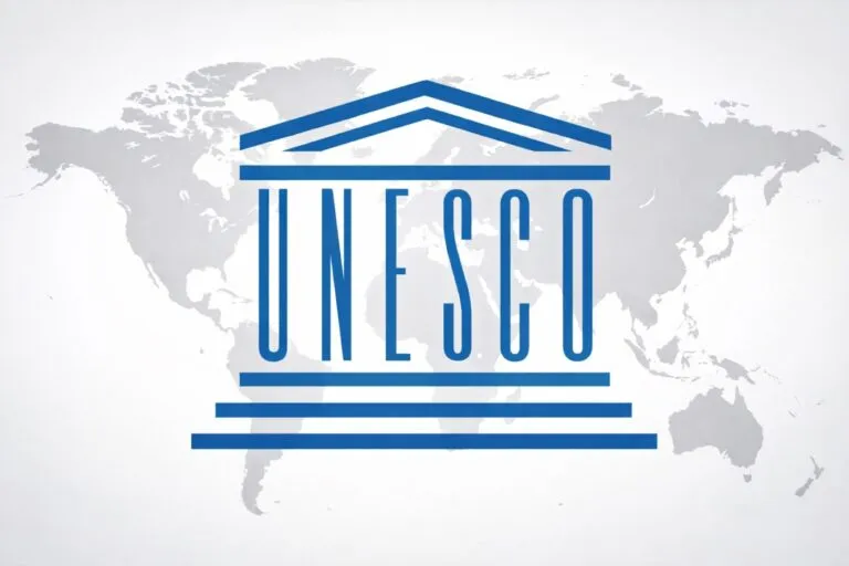 Logotipo de la UNESCO con mapa mundial de fondo, representa el compromiso global con la alfabetización digital