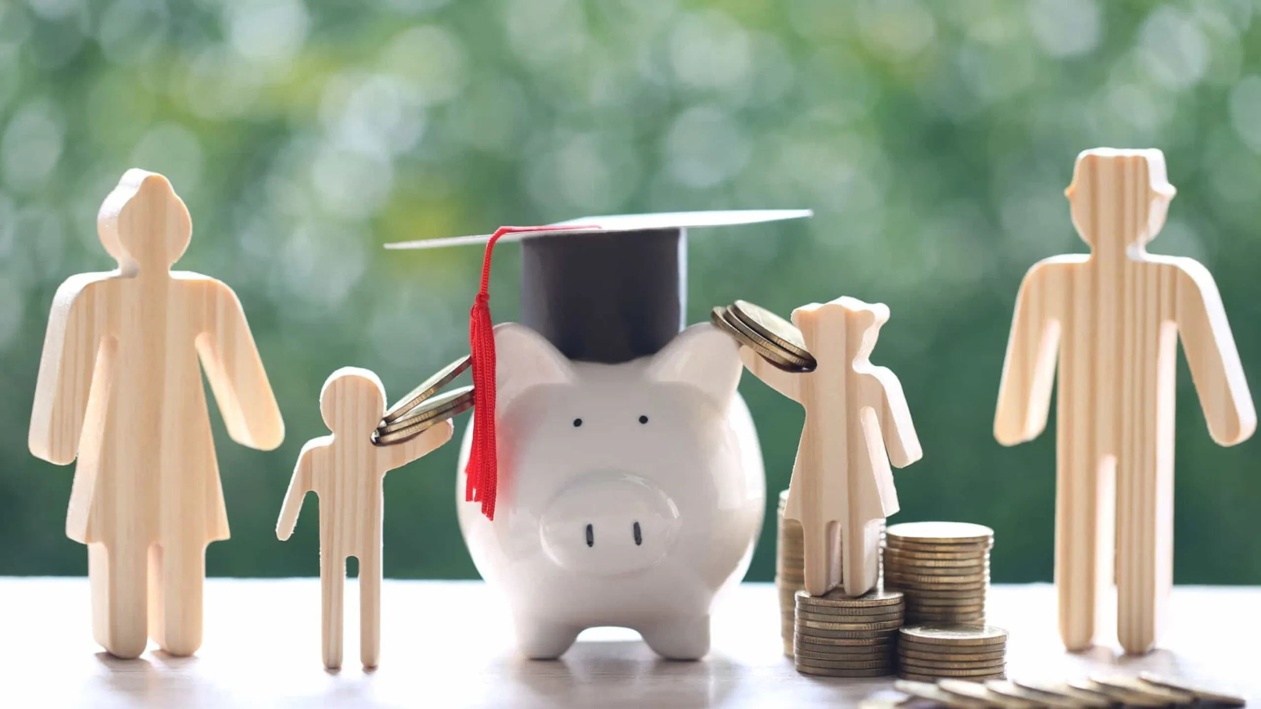 Alcancía con birrete rodeada de figuras familiares y monedas representa la educación financiera y planificación económica para estudios y créditos