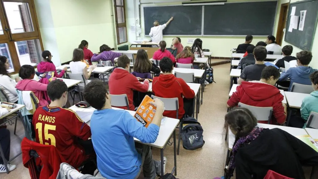 profesor en aula con estudiantes reflejando los desafíos de la educación pública en España y el entorno escolar actual