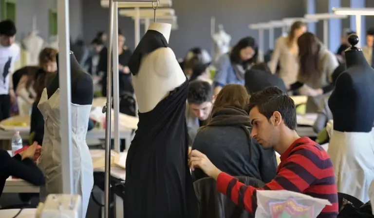 Estudiantes trabajan en atelier de escuelas de moda donde se forman diseñadores para la industria global.