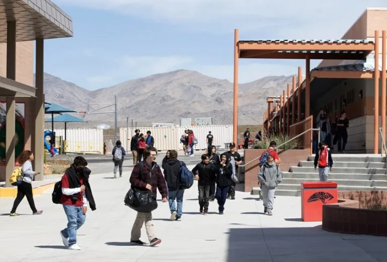 Escuela rural en Estados Unidos con estudiantes llegando en autobús escolar, reflejando los desafíos actuales de las escuelas rurales.