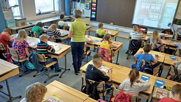 Niños en aula escolar participando en actividades educativas reflejan el modelo de transición escolar en Finlandia y su impacto en el aprendizaje infantil.