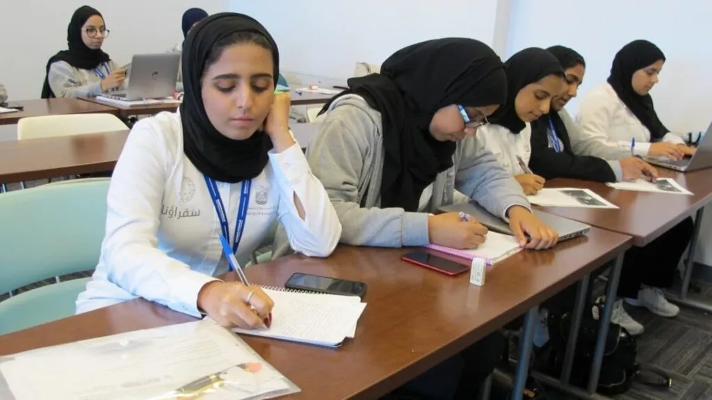 educación digital en Medio Oriente con estudiantes usando tecnología en entornos híbridos durante crisis