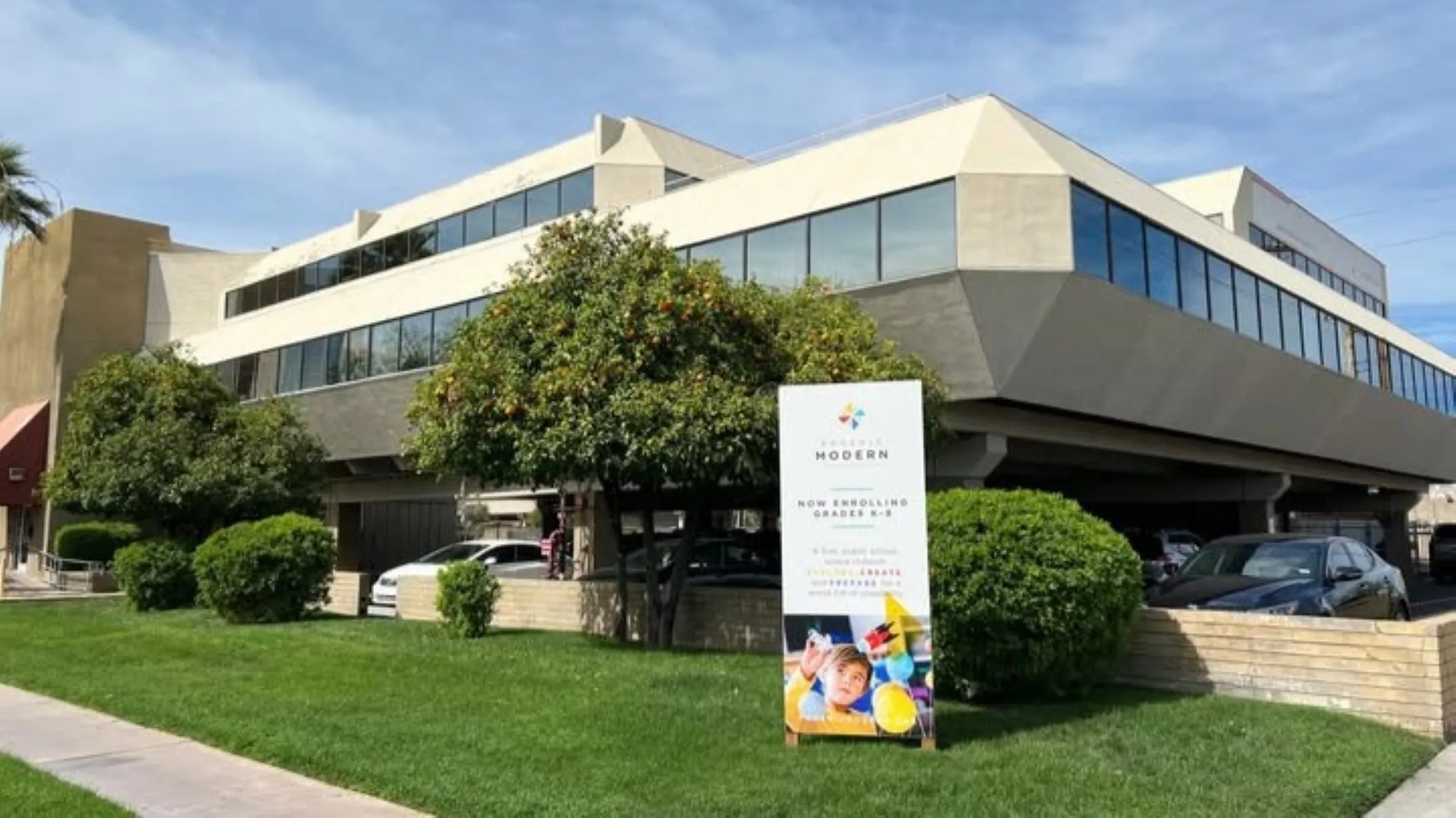 escuela de Phoenix con padres y estudiantes reunidos frente a edificio educativo en contexto de rescate comunitario