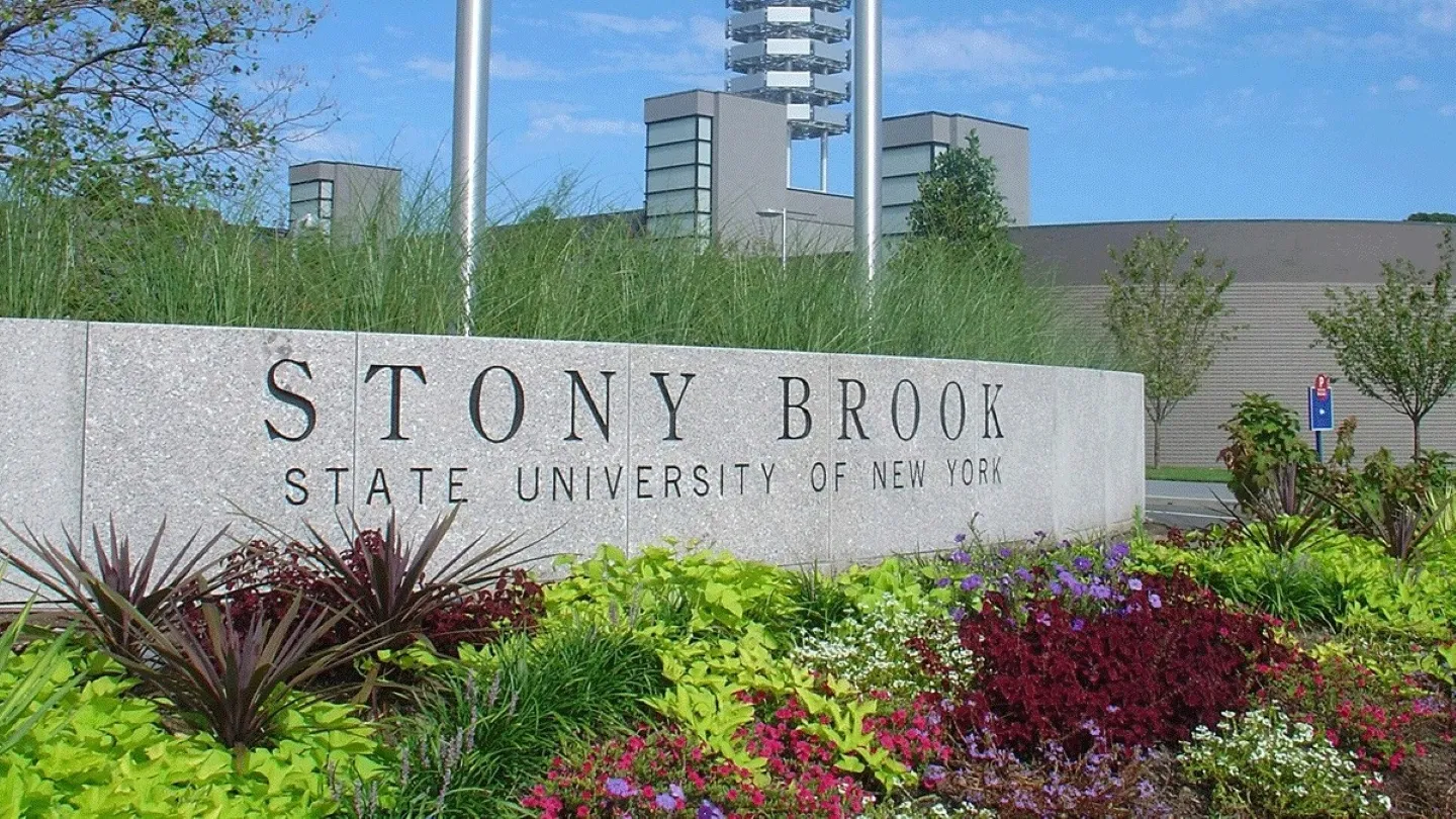 Stony Brook University campus con áreas verdes y árboles reflejando compromiso ambiental y sostenibilidad educativa